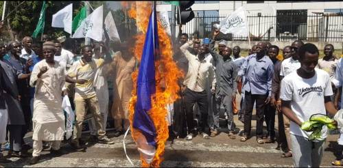 Shiites members burn France Flag over French President Magazine publication as they protest in Abuja.
